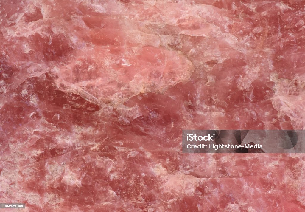 rose quartz texture - closeup of a rough rose quartz stone surface structure for backgrounds A rose colored quartz stone texture / structure, part of a larger rose quartz rock with a natural shape and a rough surface. The closeup is well usable for backgrounds and textures. Red Stock Photo