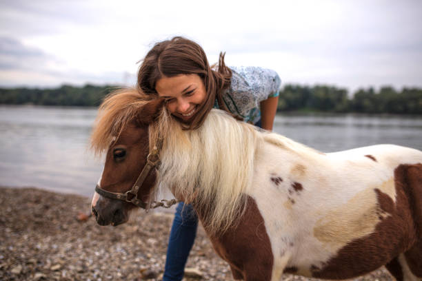 istock Woman with her pony by river 1039269252