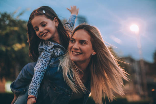istock Mother carrying small daughter on a piggyback 1039273072