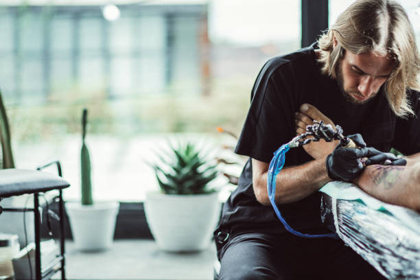 istock Artist making tattoo on man's leg 1039293358