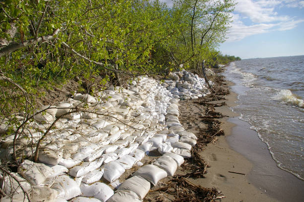 A sandbag wall by a swollen lake