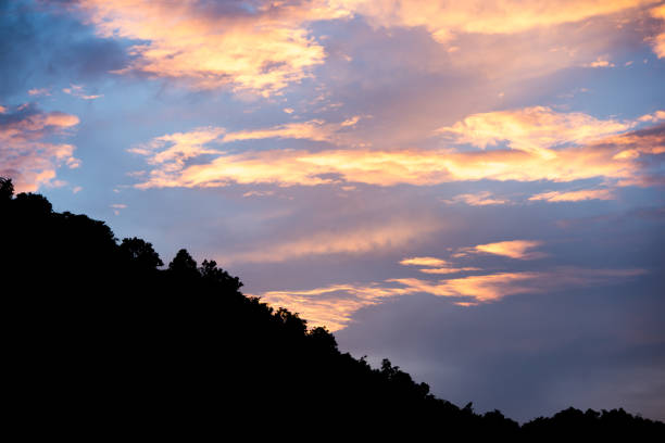 istock colorful cloudy sky with blue orange and silhouette tree canopy on mountain at bottom 1039328610