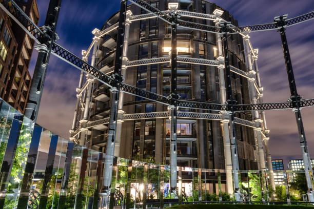 Gasholder at night, Regents Canal, London Empty gasholder at Gasholder Park, Regents Canal, London, England. Fllodlit at night. regents canal stock pictures, royalty-free photos & images