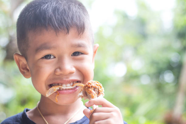 istock child eating a fries chicken leg. 1039347800