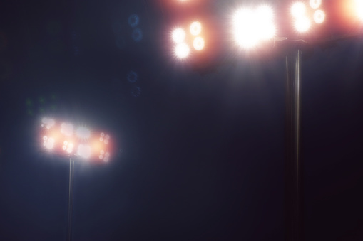 luces del estadio en el juego de deporte en fondo de cielo oscuro de la noche photo