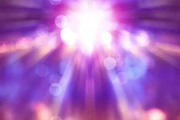 Photo of blurred theatre show with purple light on stage, abstract image of concert lighting