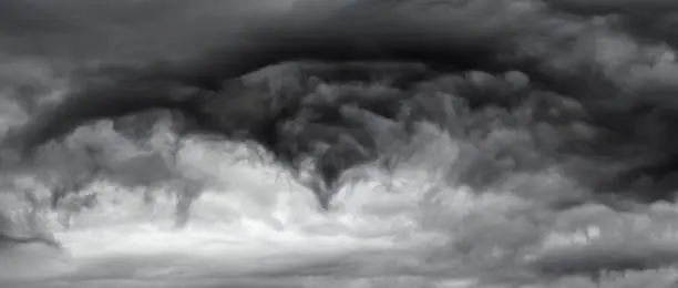 Dramatic vortex of storm clouds in monotone