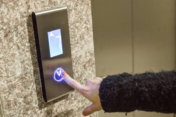istock Woman is pressing a button of elevator door 1039383854