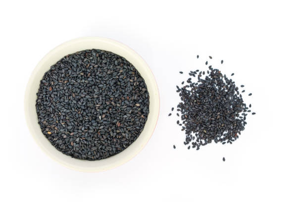 istock Black sesame in white bowl on white background top view. 1039401340