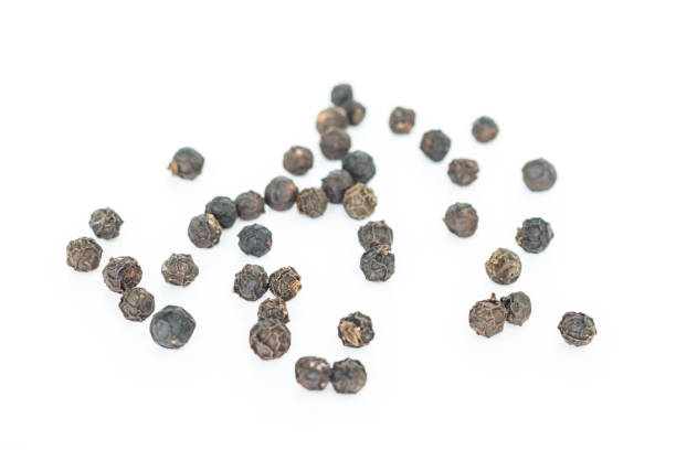istock black peppercorns heap on white background. 1039407588