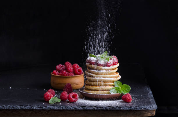 istock Pancakes with raspberries and berries around on black backgound 1039465642