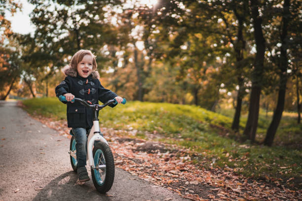 istock Happy small boy riding bicycle through autumn park. 1039467252