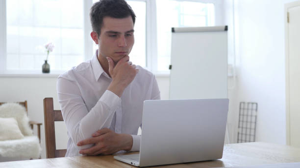 istock Pensive Businessman Thinking and Working on Laptop 1039472982