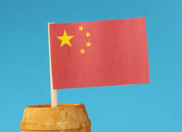 Photo of A detail on paper national flag of China on wooden stick in wooden barrel