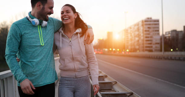 istock Young attractive couple running outside on sunny day 1039491104