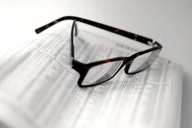 istock Speckled Eyeglasses on a Folded Newspaper - Stock Quotes 103951085