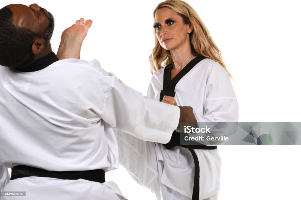 Applied Self-Defense Kick Martial artist practicing self-defense with her partner. Adult Stock Photo
