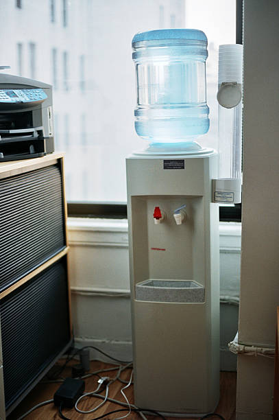 Man filling plastic cup at water cooler