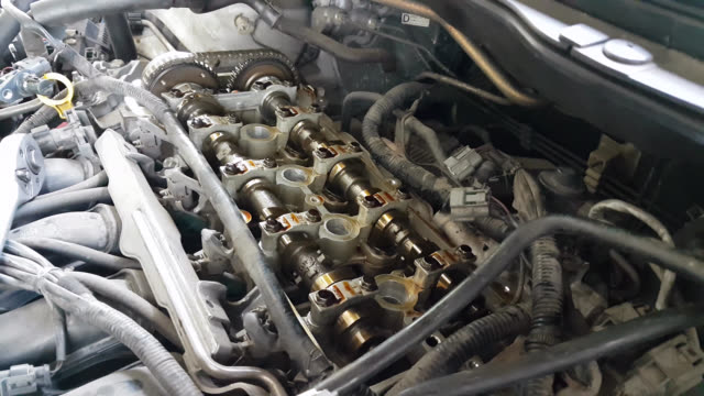 Mechanic fixing cylinder head with camshaft of car engine