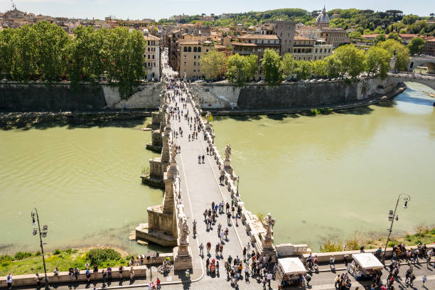 personas caminando en el puente de sant'angelo a lo largo del río tíber en roma - aelian bridge fotografías e imágenes de stock