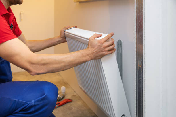 man installing room heater on the wall man installing room heater on the wall radiator heater stock pictures, royalty-free photos & images