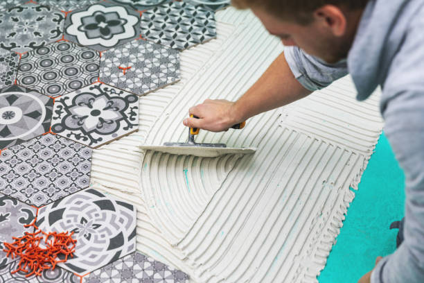 worker applying tile adhesive on the floor - tile adhesive imagens e fotografias de stock