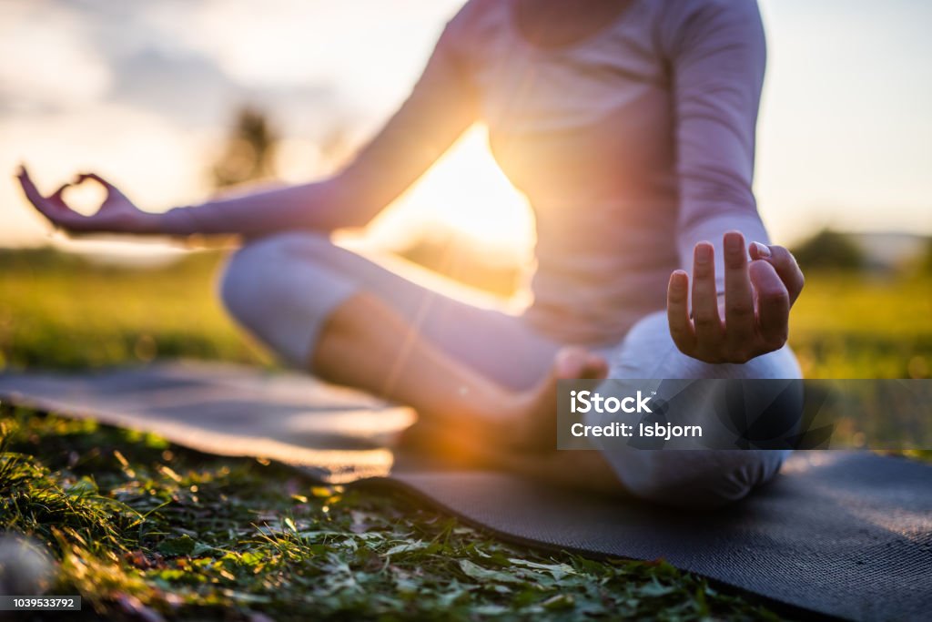 Close up of meditation in park at sunrise. Close up of yoga outdoor at sunset. Yoga Stock Photo