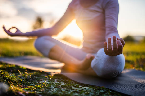 close up of meditation in park at sunrise. - ioga imagens e fotografias de stock