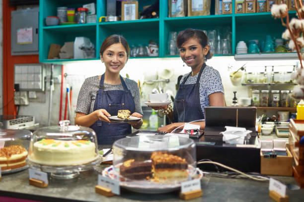 istock Smiling female owner and barista working in cafe 1039536962