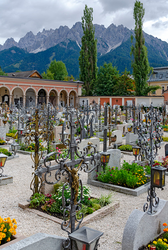 grave crosses at the cemetery of Dobbacio with the mountain Haunold, part of the Sextner Dolomites, in the background, Italy