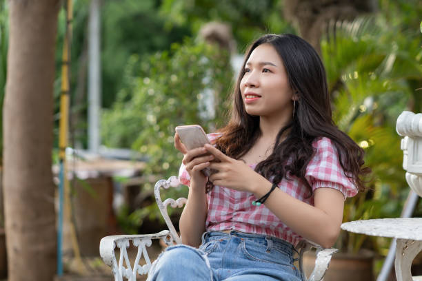 istock Asian woman are using smart phone in park 1039557210