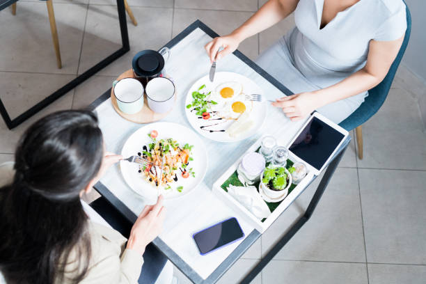 istock Two Women Enjoying Meal in Cafe 1039557668