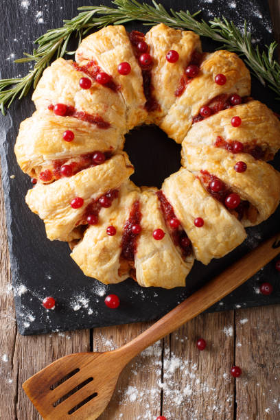 istock Christmas food: pie with meat, cranberries, rosemary and cheese close-up. Vertical top view 1039560448