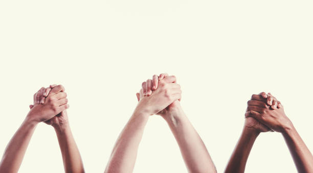istock Three mixed pairs of clasped hands raised in congratulation 1039565956