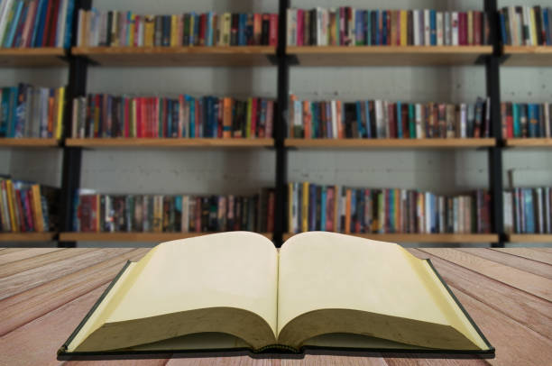 Open textbooks on reading desk in blurred library room background