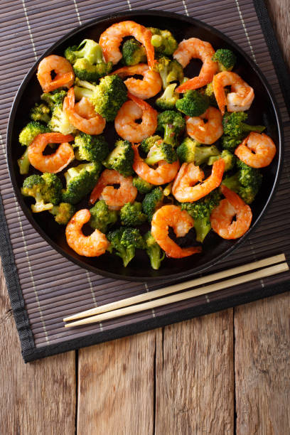 istock Stir frying shrimp with broccoli closeup. Vertical top view 1039574346