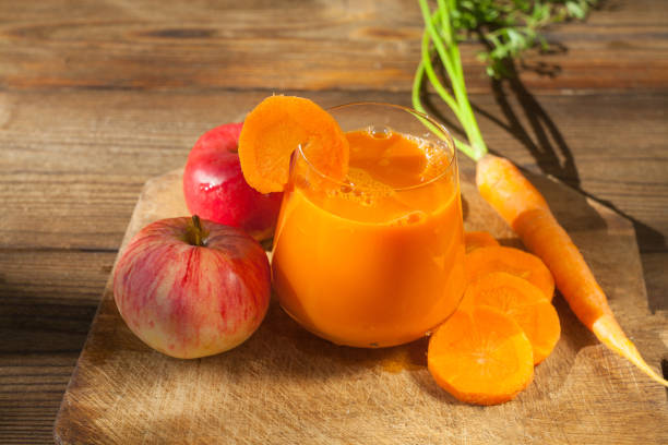 suco de cenoura em vidro sobre a mesa - carrot juice - fotografias e filmes do acervo