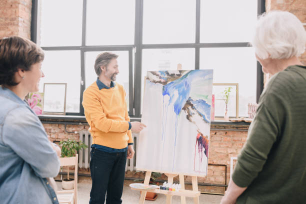 istock Mature Artist Presenting Painting 1039587266