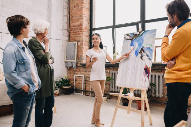 istock Young Woman Presenting Painting in Art Studio 1039587272