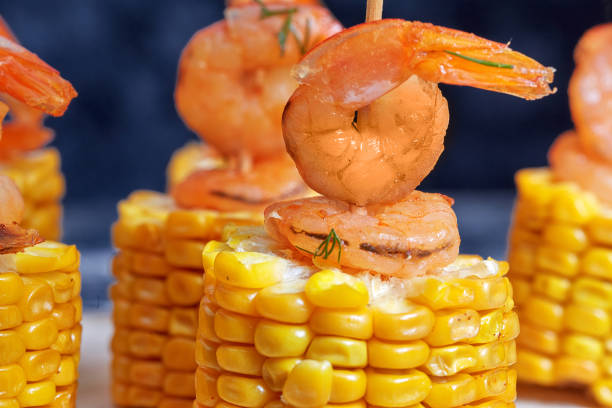 Grilled spicy corn on the cob with shrimp served skewer