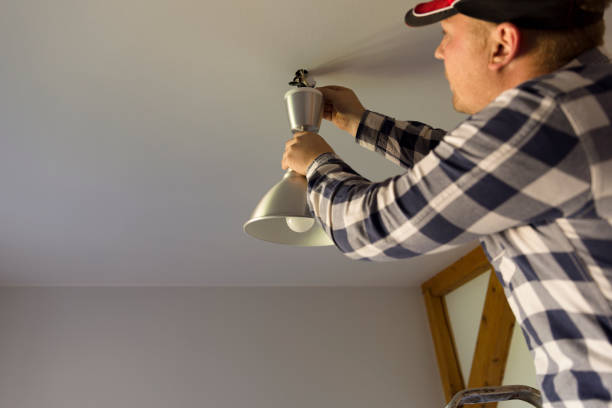 istock the electrician installs the ceiling lamp 1039604466