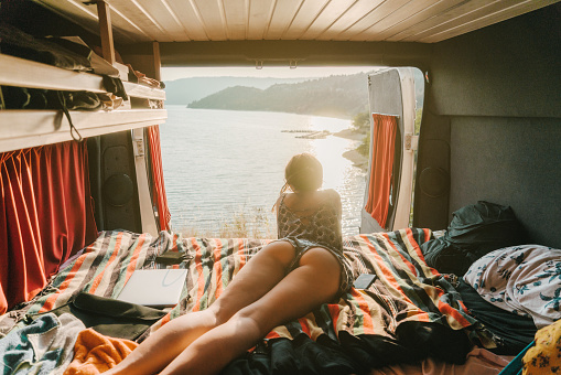 Young Caucasian woman looking at scenic  view of Lake of Sainte-Croix from campervan