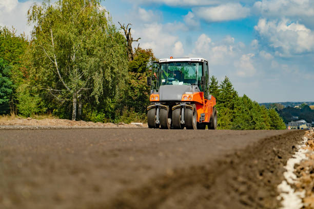 istock a steamroller with four wheels rides through the fresh asphalt to level the surface. 1039611092