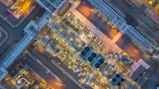 Photo of Aerial top view oil and gas refinery plant form industry zone at night.