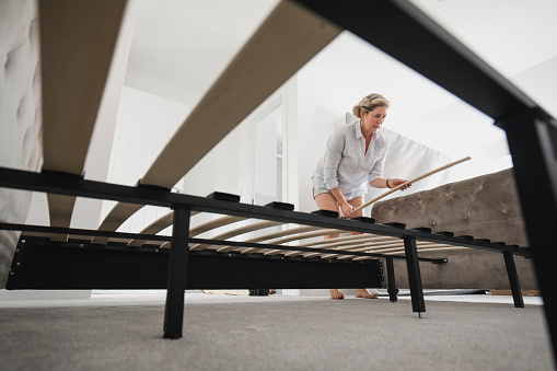 Mature Woman Building Bed in New Home