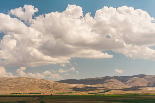 istock Big sky with big white clouds and hills beneath. Nature. 1039629492