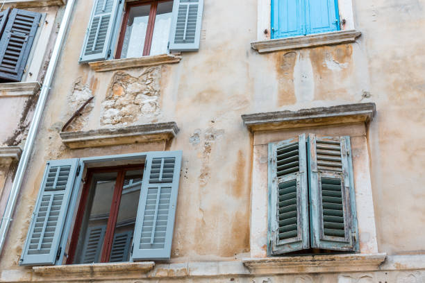 Old windows with blue shutters in the old house. Vintage background, texture