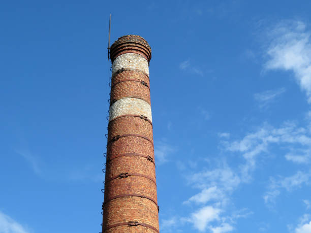 istock Red brick pipe on the background of the blue sky with white clouds 1039653944