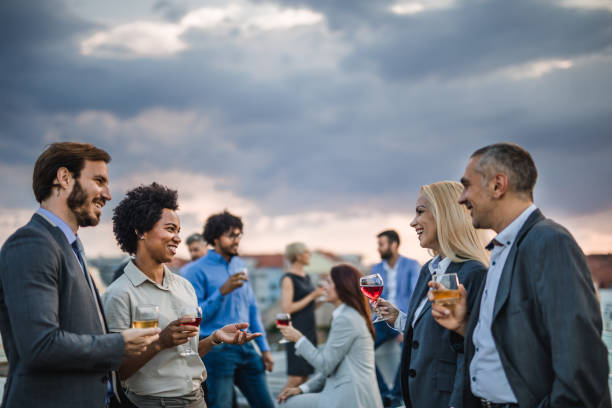 istock Happy business people talking while drinking alcohol on a rooftop party. 1039657440