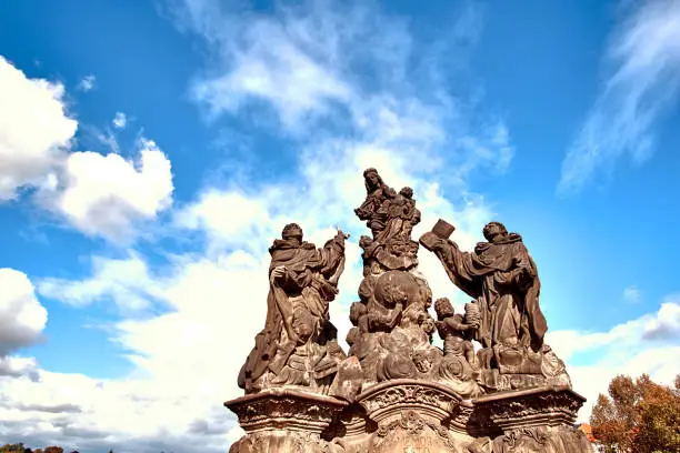 Photo of Virgin Mary statue at the Charles Bridge (Karluv Most) in Prague, Czech Republic. Close up view with blue sky